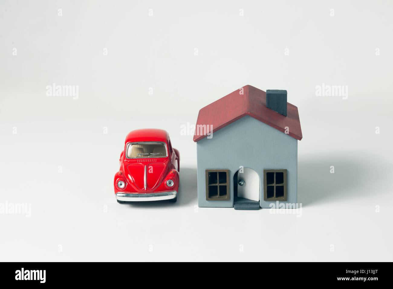Izmir, Turquie - 1 Avril 2017 : petite voiture rouge et miniature house sur un fond blanc. Banque D'Images
