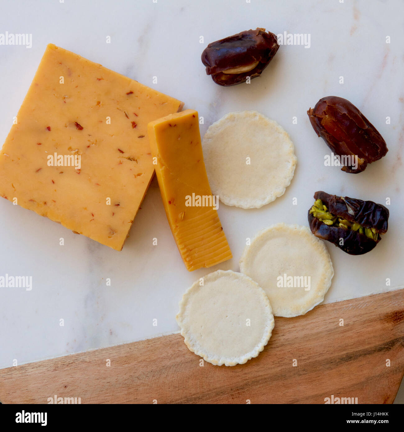 Fromage épicé chipotle sur une carte avec des biscuits et des dates. Banque D'Images