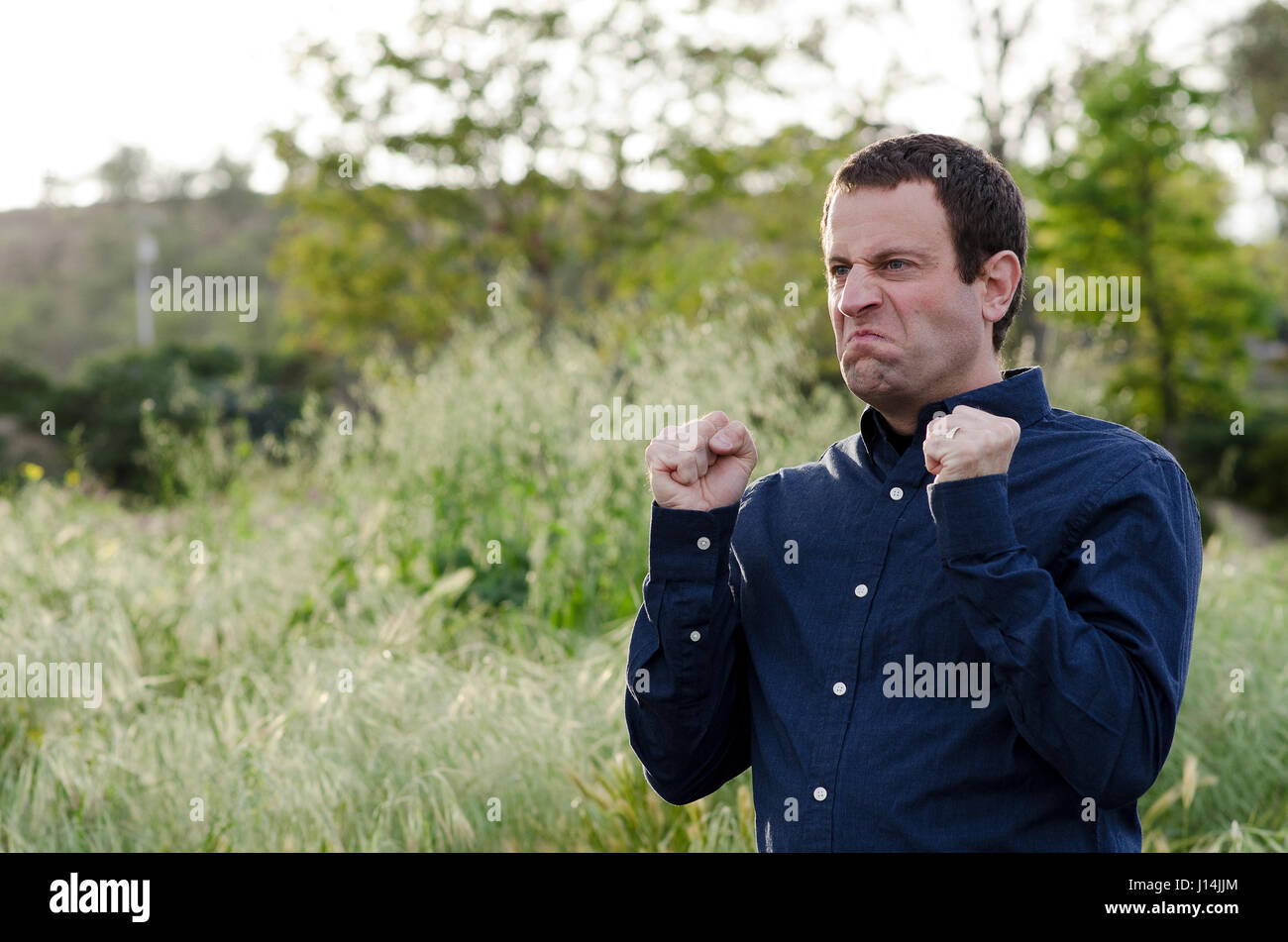 Homme en colère à l'extérieur de serra de faire un visage en colère. Banque D'Images