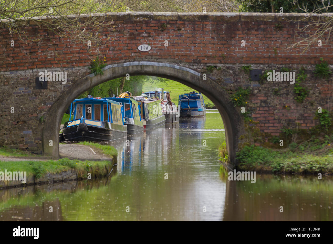 Péniches amarrées sur le Shropshire Union Canal encadré par un vieux pont une escapade de vacances populaires et style de vie Banque D'Images