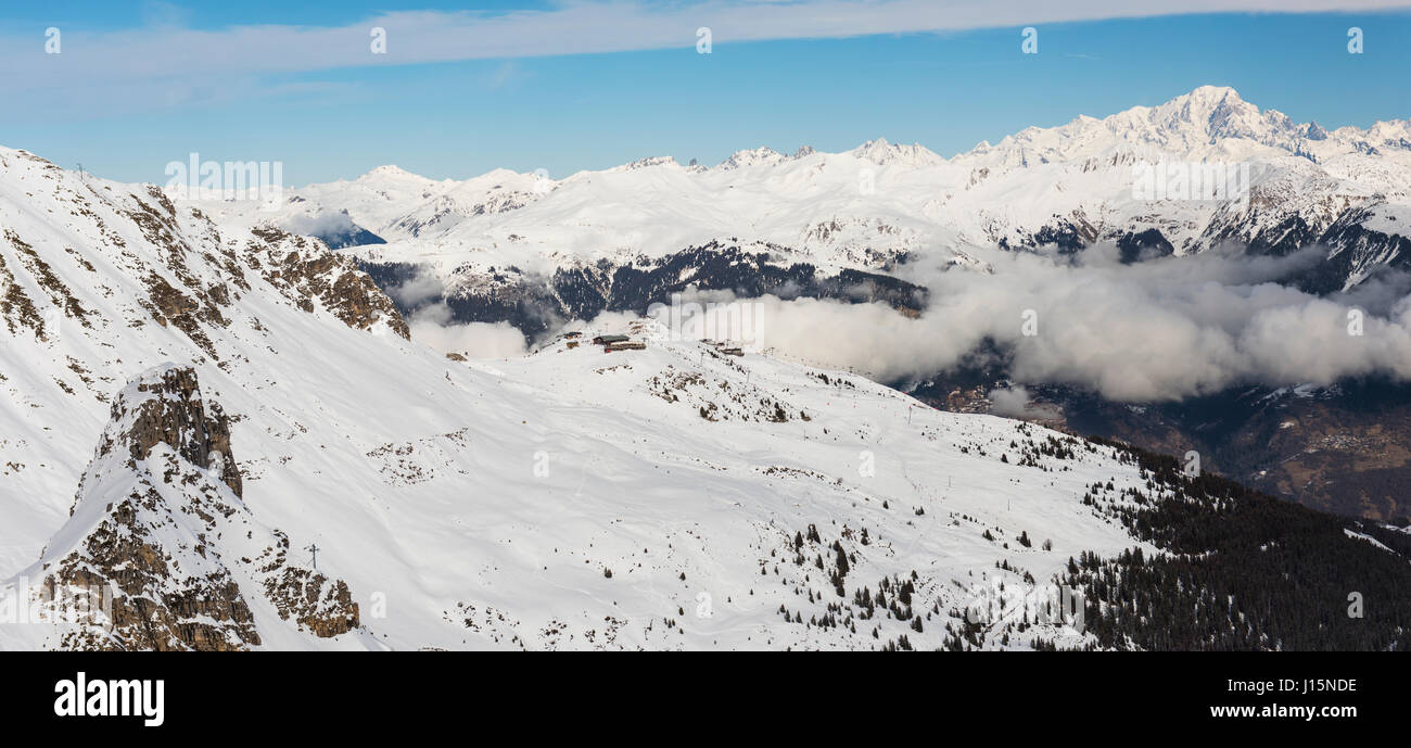 Aerial high angle vue panoramique vers le bas de la vallée couverte de neige en montagne alpine avec les cumulus Banque D'Images