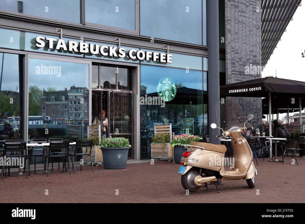 Scooter en face d'un café Starbucks Banque D'Images