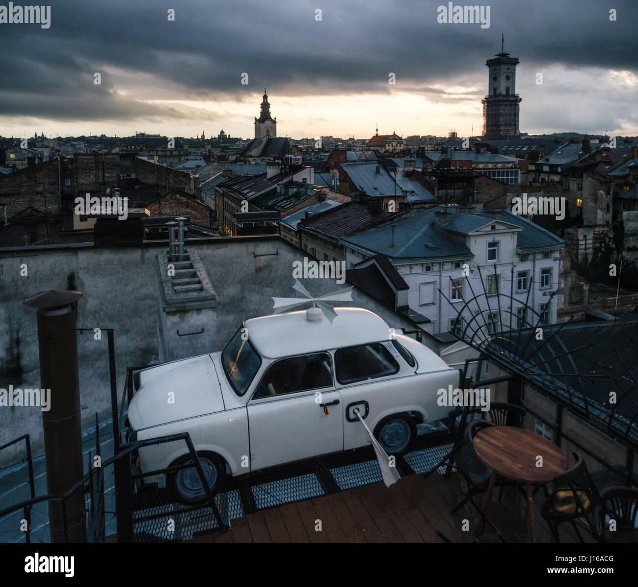 Lviv, Ukraine - le 22 septembre 2016 : Tuning voiture garée sur le toit d'un bâtiment historique Chambre des légendes dans le crépuscule. Vue de Lviv, Ukraine. Banque D'Images