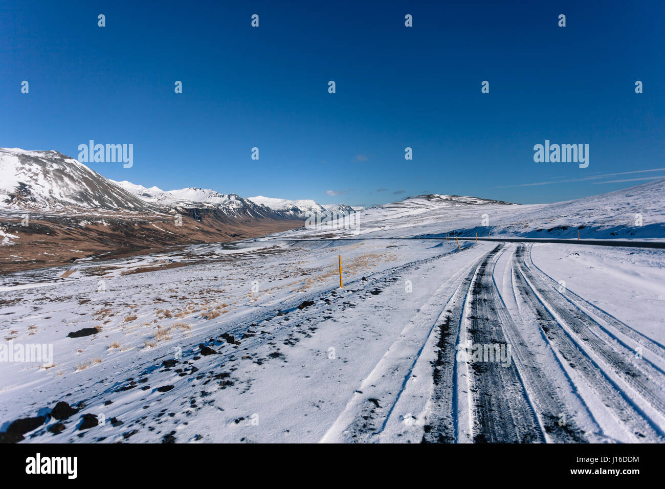 Traces dans la neige couverts route de montagne juste à l'extérieur, Ólafsvik (péninsule de Snæfellsnes Snæfellsnes), dans l'ouest de l'Islande Banque D'Images