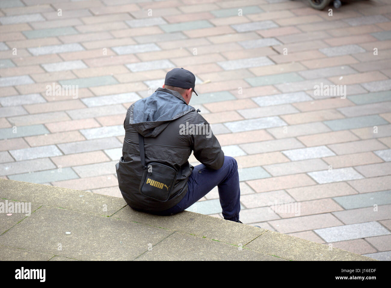Jeune homme d'immigrants ou de réfugiés de s'asseoir sur le Glasgow concert hall comme suit à la jonction de Buchanan Street et Sauchiehall Street Banque D'Images
