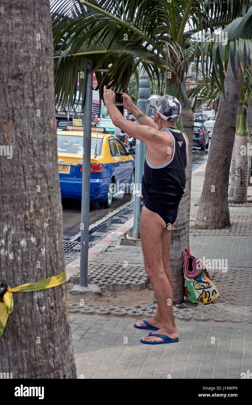 Très légèrement vêtue à l'aide d'un touriste mâle smartphone pour prendre des photos. La Thaïlande Asie du sud-est Banque D'Images