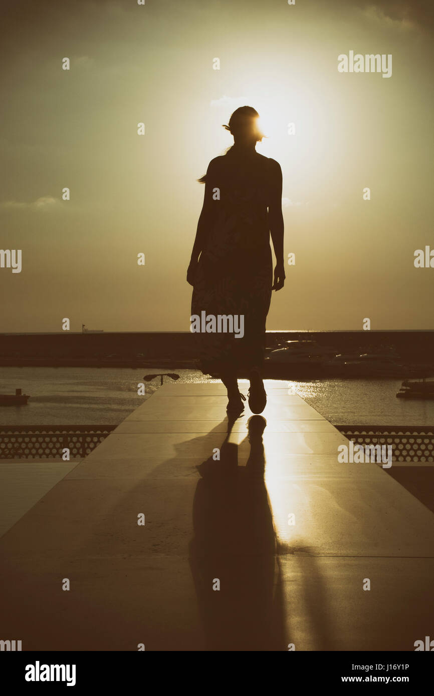 Longueur totale silhouette d'une femme au coucher du soleil Banque D'Images