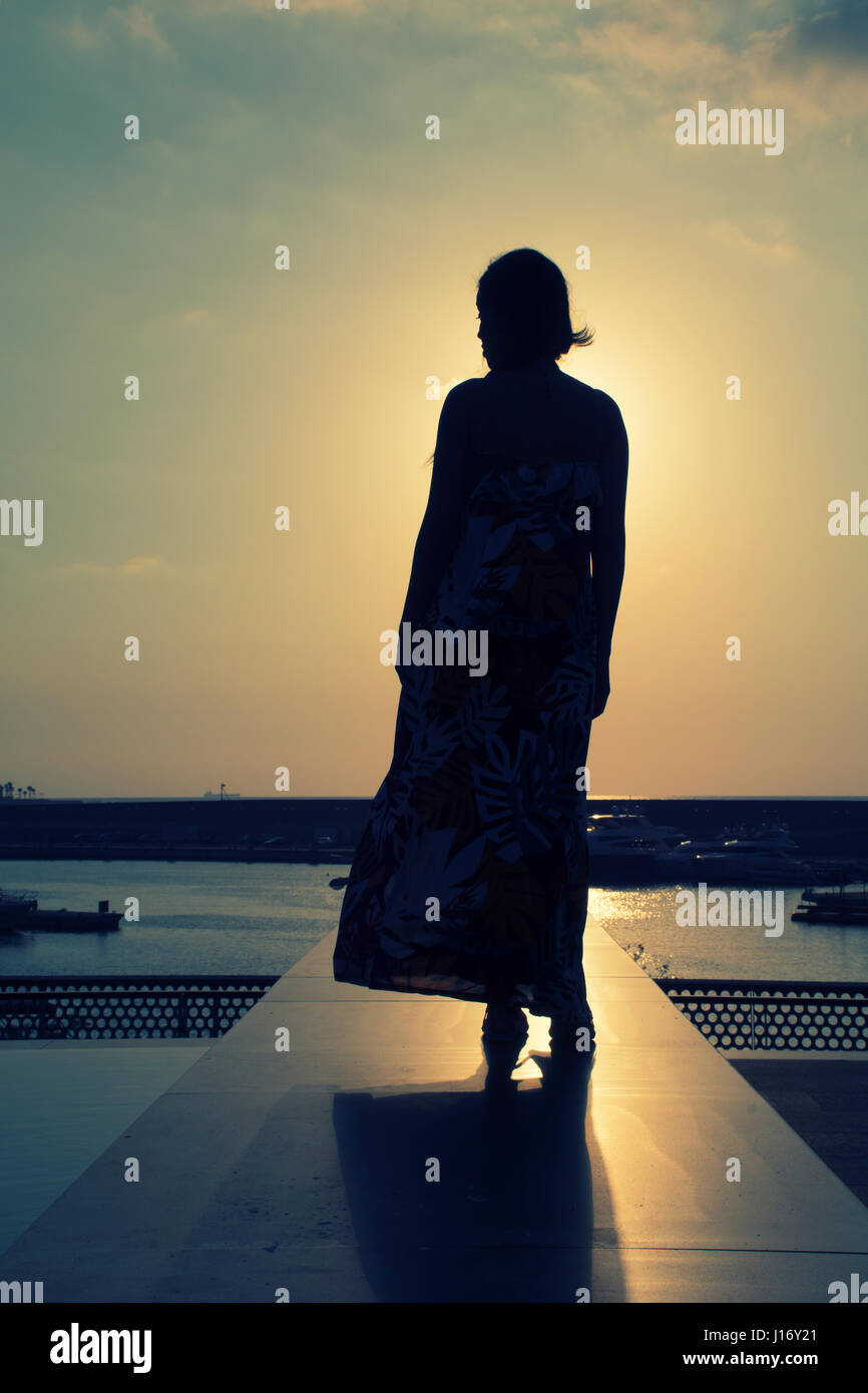 Longueur totale silhouette d'une femme au coucher du soleil Banque D'Images