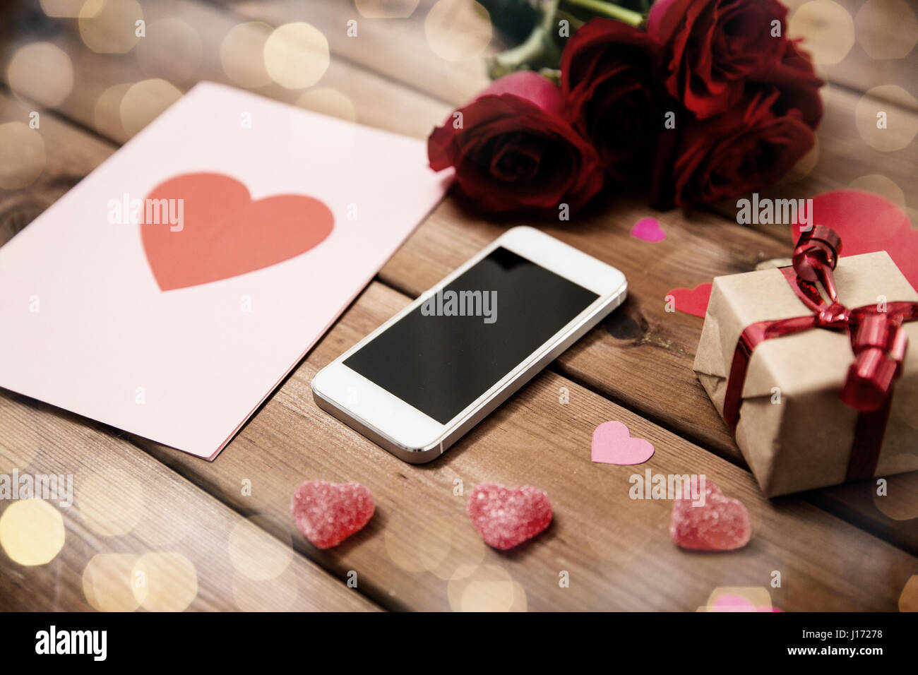 Close up of smartphone, cadeau, roses rouges et les cœurs Banque D'Images
