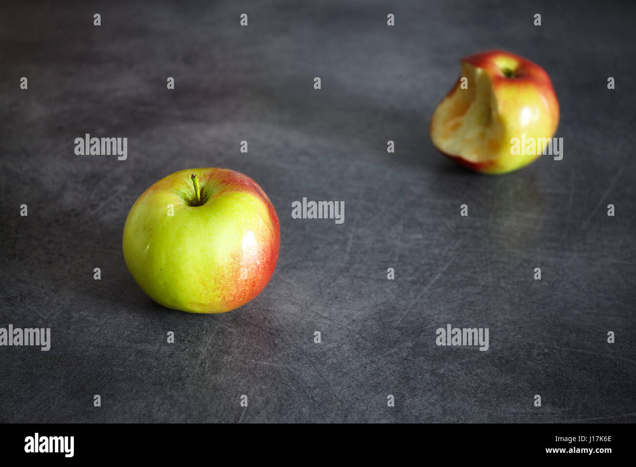 Deux pommes mûres, un ensemble et un piqué sur un fond sombre, selective focus, de l'espace pour le texte. Banque D'Images