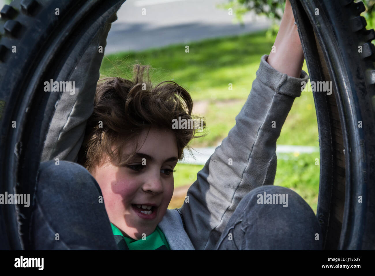 Garçon jouant sur rope swing, UK Banque D'Images