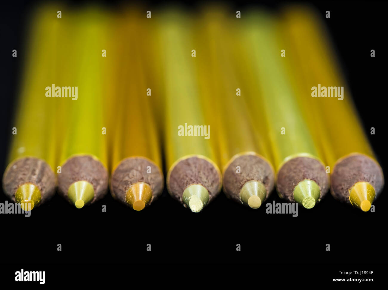 7 crayons de couleur jaune de différentes teintes et nuances avec un fond noir. Choisies, seulement sur le crayon points. Banque D'Images