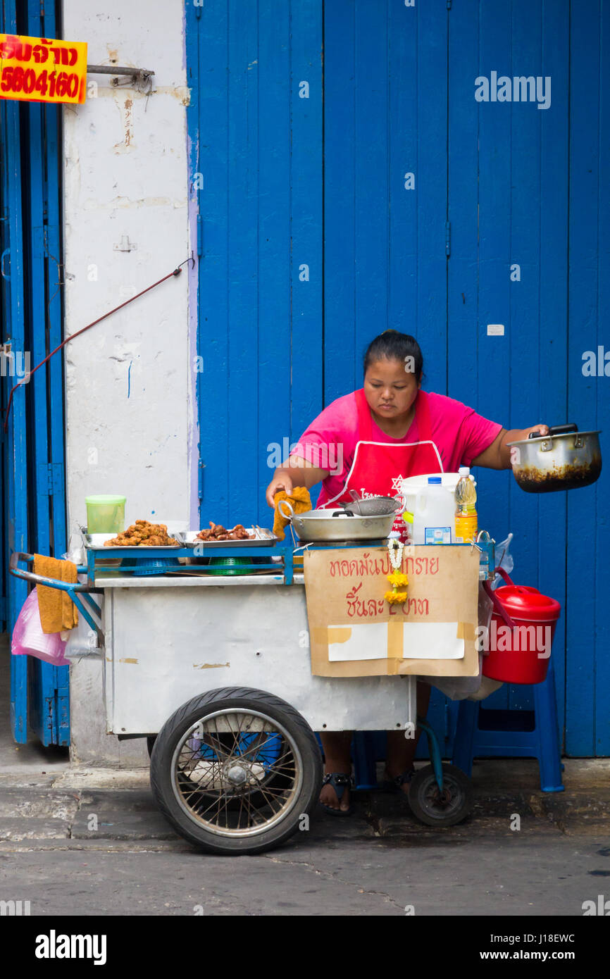 Femme de vendeurs d'aliments de rue contre un bleu et blanc, Bangkok, Thaïlande Banque D'Images