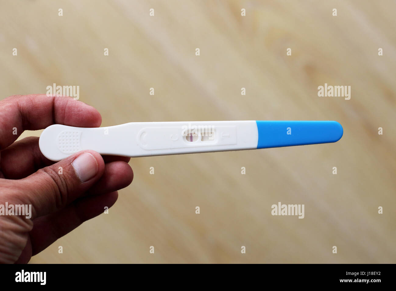 Hand holding Test de grossesse contre isolé sur fond blanc Banque D'Images