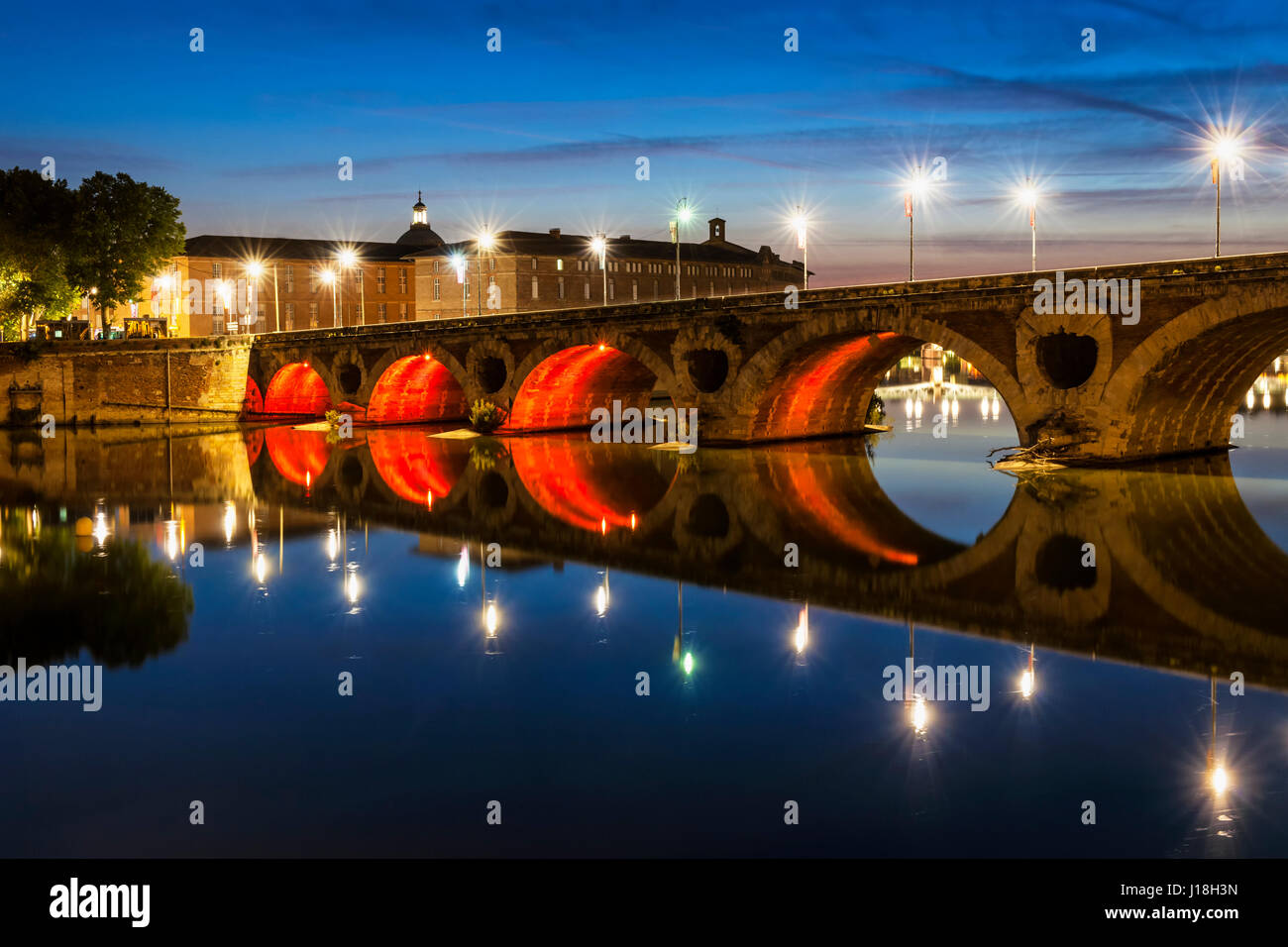 Soir view of historic Pont Neuf à Toulouse, en France, avec des arcs lumineux sur Garonne. Banque D'Images