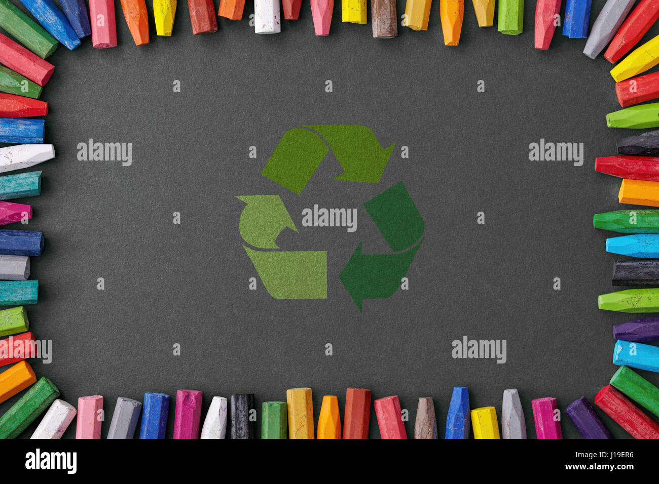 Recycle sign sur tableau noir entouré de crayons de couleur Banque D'Images