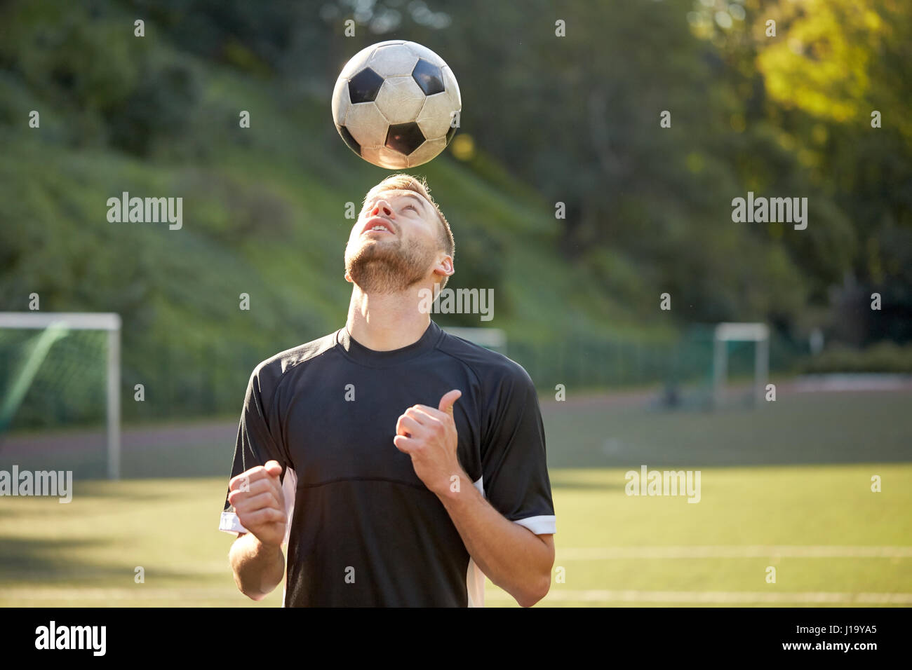 Joueur de football Playing with ball on field Banque D'Images