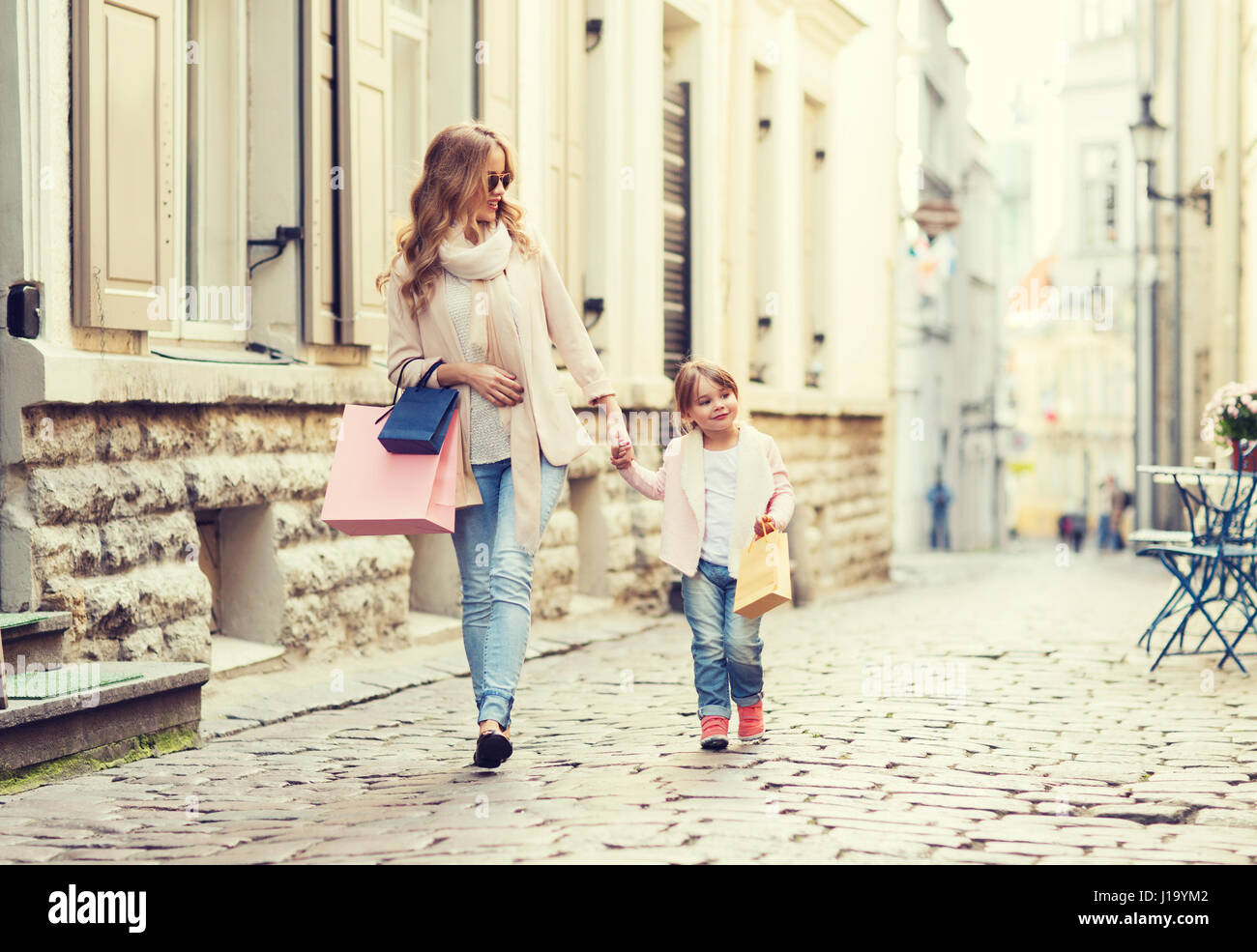 Happy mother and child with shopping bags in city Banque D'Images