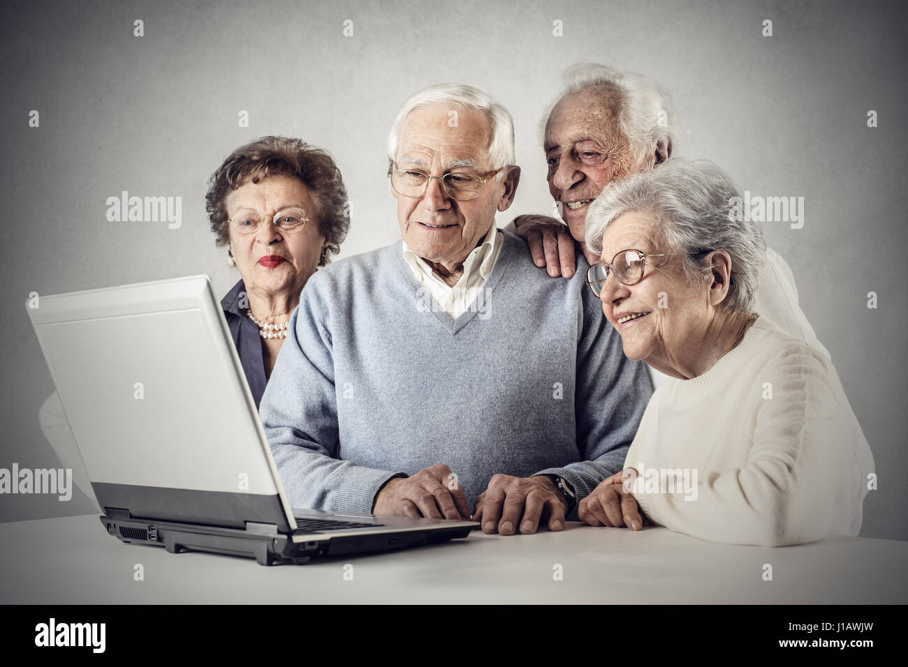 2 vieux hommes et 2 femmes looking at laptop Banque D'Images