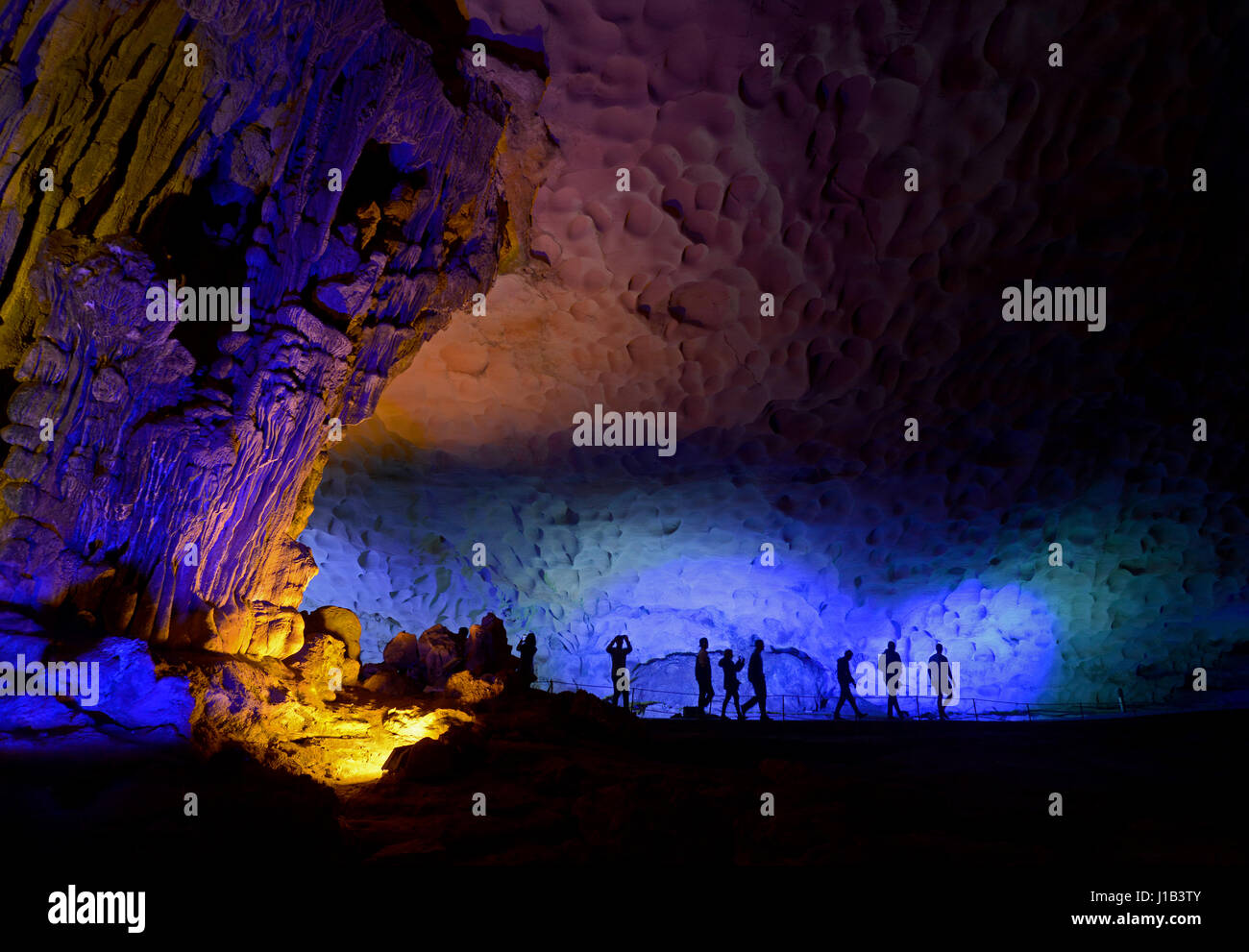 La Silhouette de touristes se rendant sur les Grottes Sung Sot (Grotte étonnant) sur l'Île Bo député dans la baie d'Halong, Vietnam, qui est un UNESCO World Heritage Site. Banque D'Images