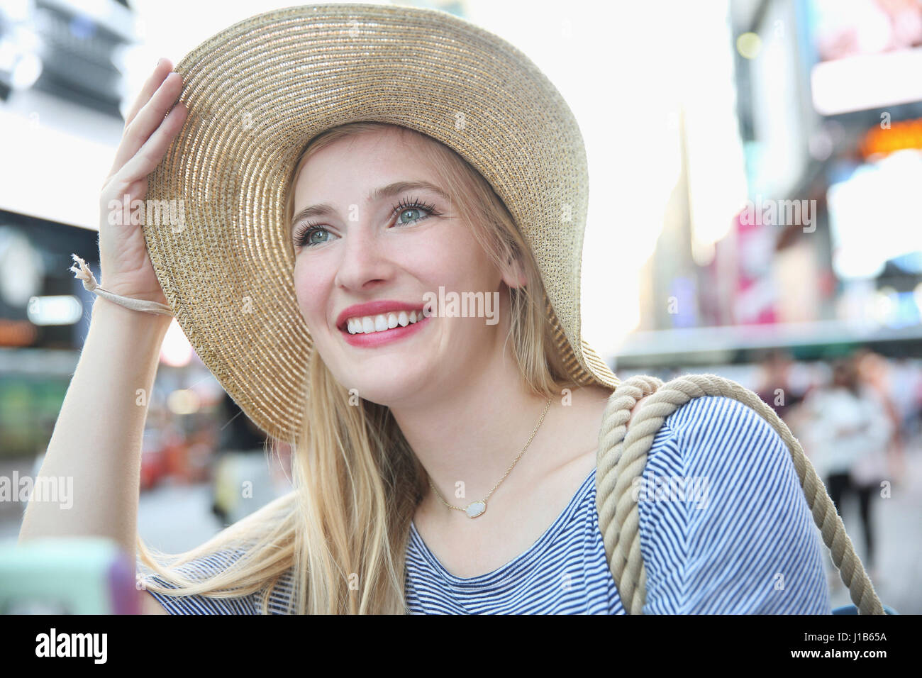 Portrait of smiling Caucasian woman wearing hat in city Banque D'Images