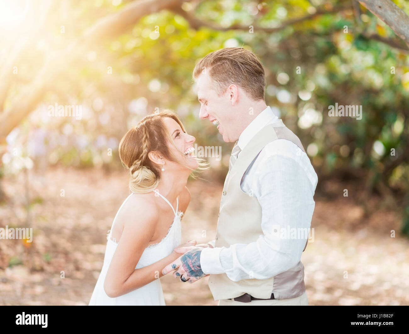 Caucasian Bride and Groom laughing outdoors Banque D'Images