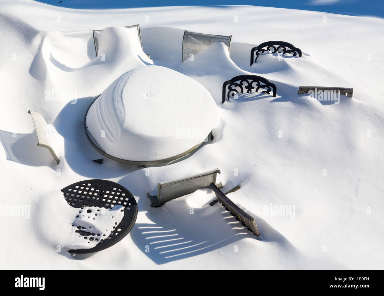Mobilier de jardin extérieur enfoui par la neige en dérive profonde lors d'un blizzard en hiver Banque D'Images
