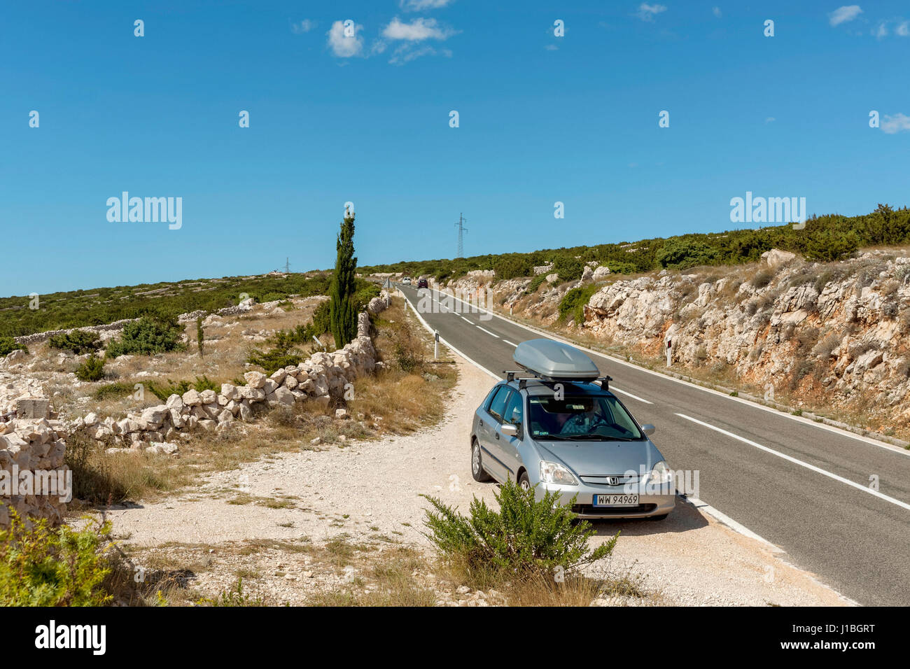 Voiture voyageurs debout sur la route, près d'Simuni, l''île de Pag, Croatie Banque D'Images