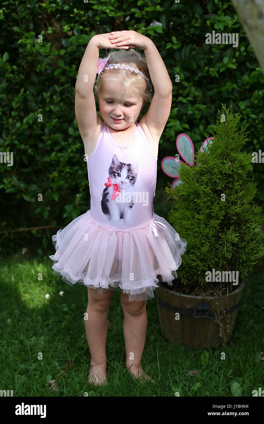 Petite fille dansant dans son tutu dans le jardin sur une journée ensoleillée Banque D'Images
