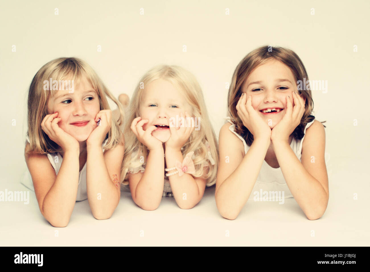 Trois sœurs portrait couché sur le ventre, blonde, joyeuse famille heureuse famille concept Banque D'Images