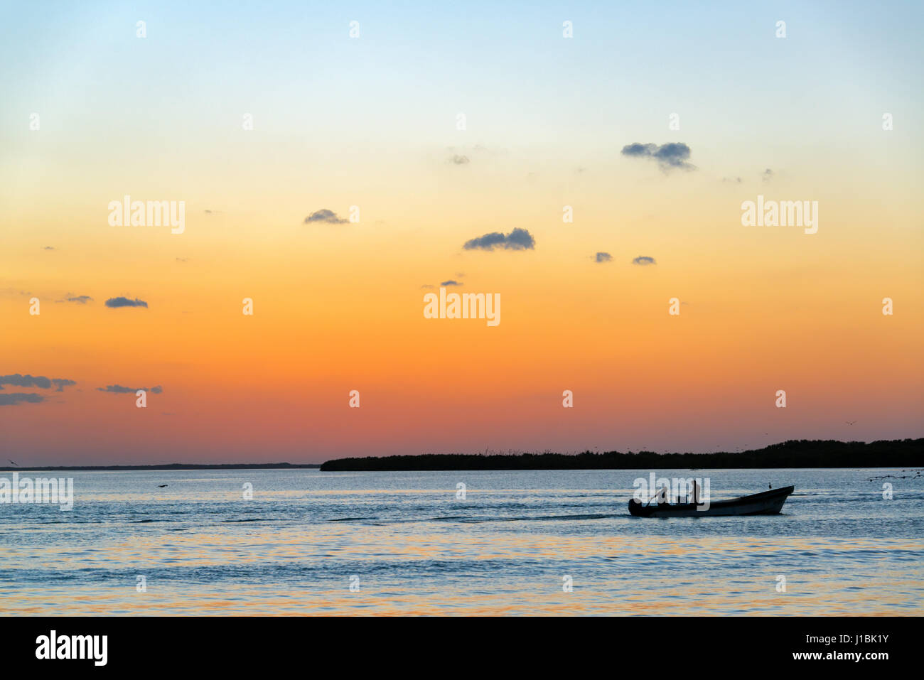 Magnifique coucher de soleil avec la silhouette d'un bateau de pêche à Rio Lagartos, Mexique Banque D'Images