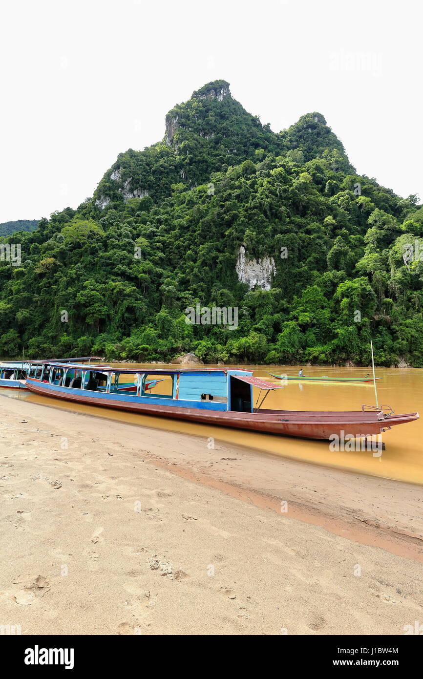 Rivière Nam Ou, Laos-October 9, 2015 : Local slowboats naviguer la rivière servant comme principaux moyens de transport en l'absence de routes terrestres. Bateaux touristiques stra Banque D'Images