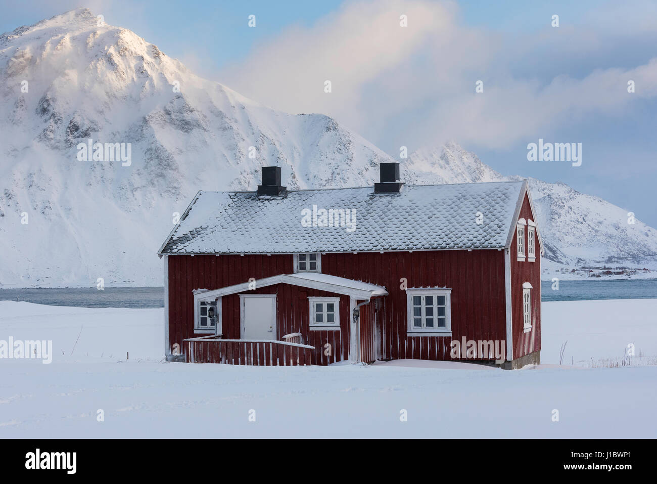 Maison rouge dans la neige près de Flakstad Flakstadoya, église, îles Lofoten, Norvège Banque D'Images