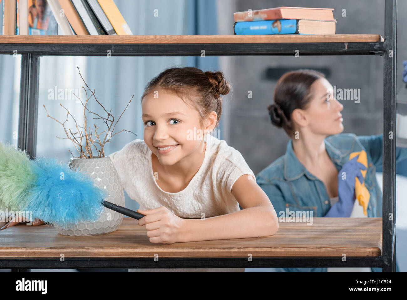 Mère et fille heureuse avec duster accueil nettoyage Banque D'Images