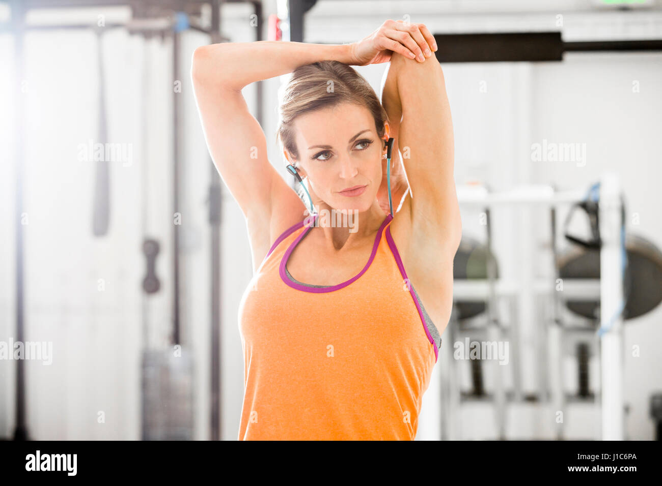 Woman stretching arm in gymnasium Banque D'Images