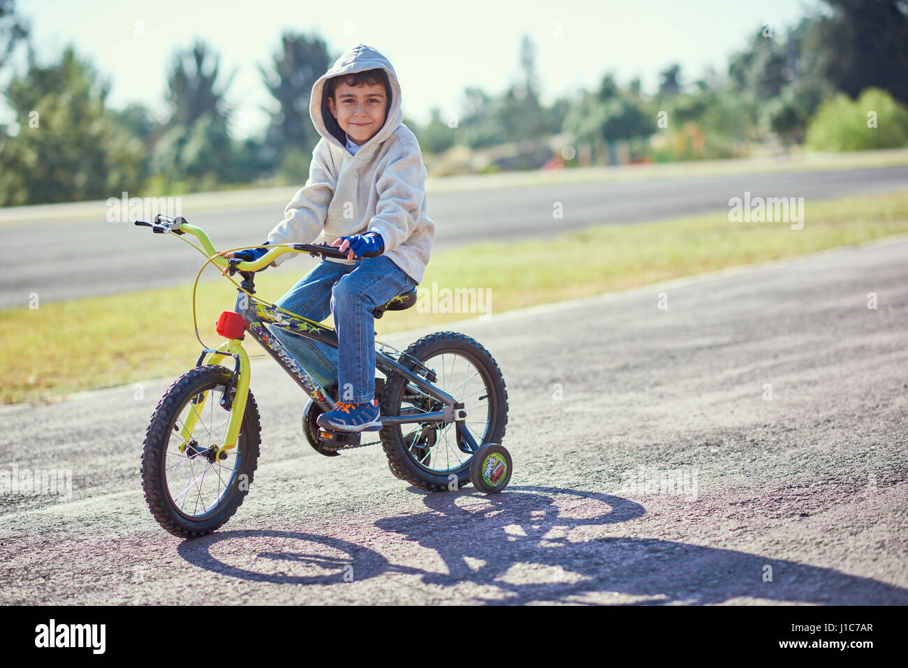 Boy posing sur vélo avec roues de formation Banque D'Images