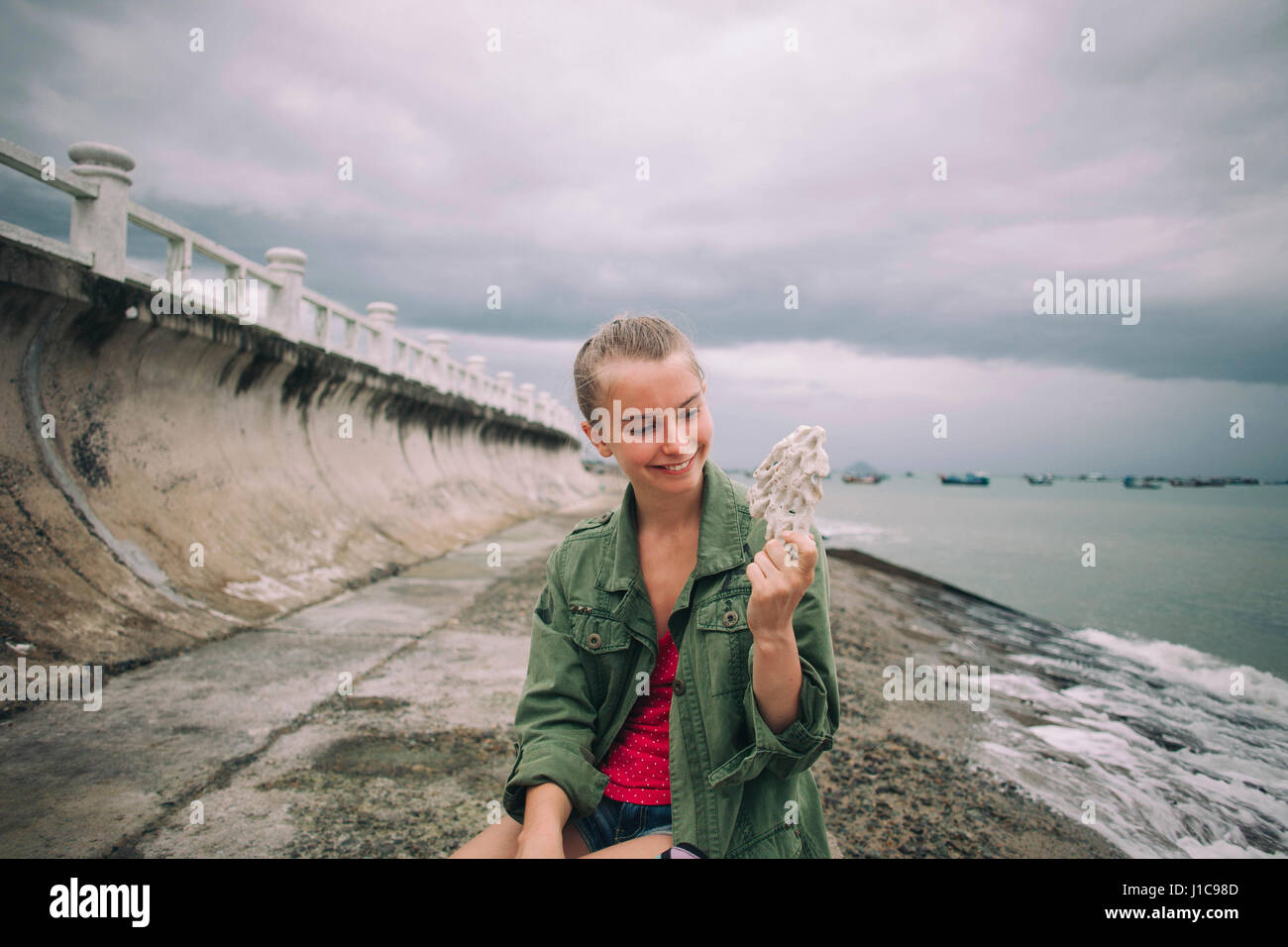Caucasian woman holding shell at beach Banque D'Images