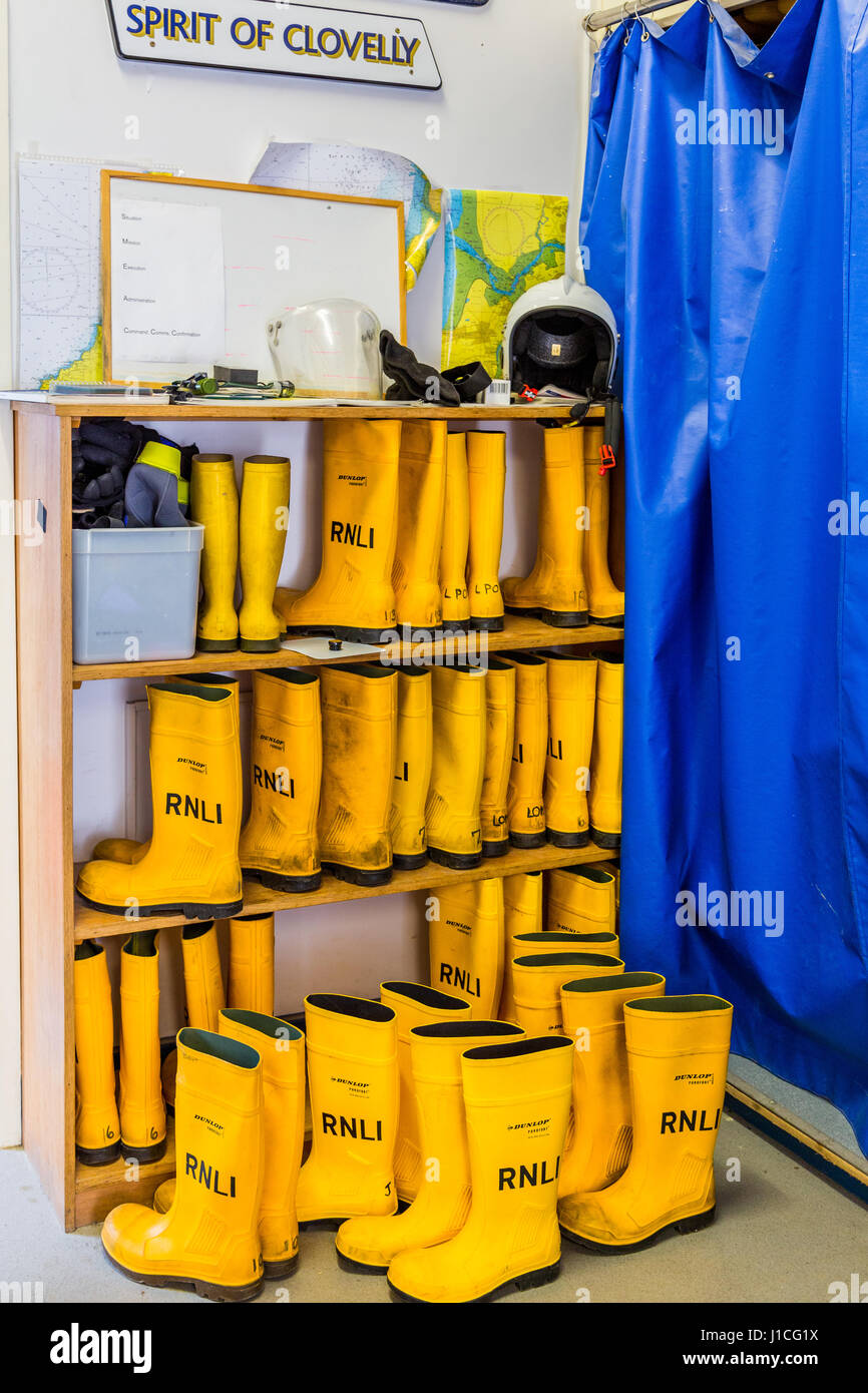 RNLI, Clovelly, Devon, UK . L'esprit de sauvetage à terre crewroom Clovelly équipage jaune soigneusement rangés dans des bottes de préparation pour le prochain appel à Banque D'Images