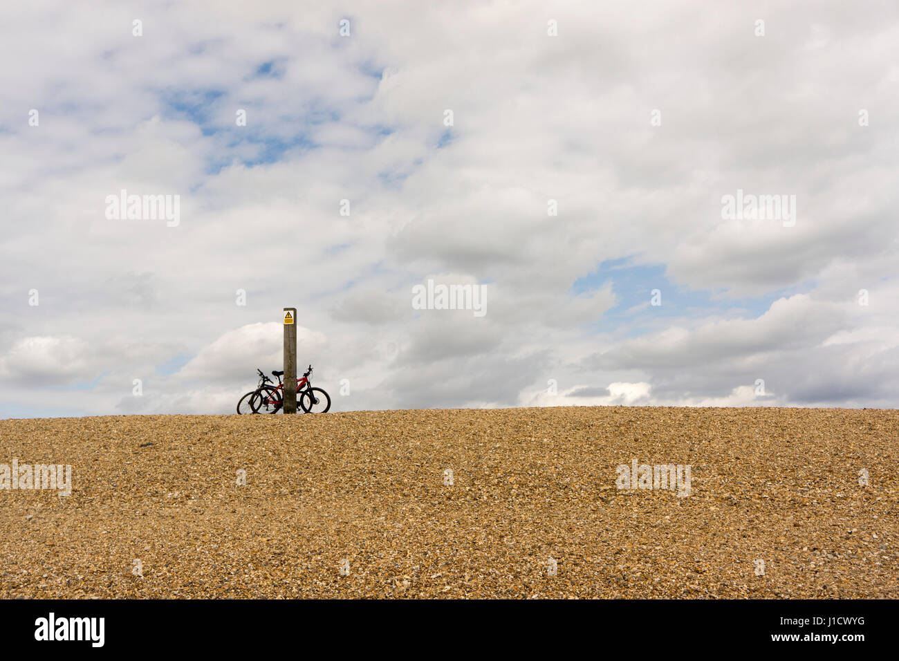 Deux vélos reste contre un poteau sur le bord d'une plage sur Hurst Spit, près de Château de Hurst dans le Hampshire, sur une journée de printemps. Banque D'Images