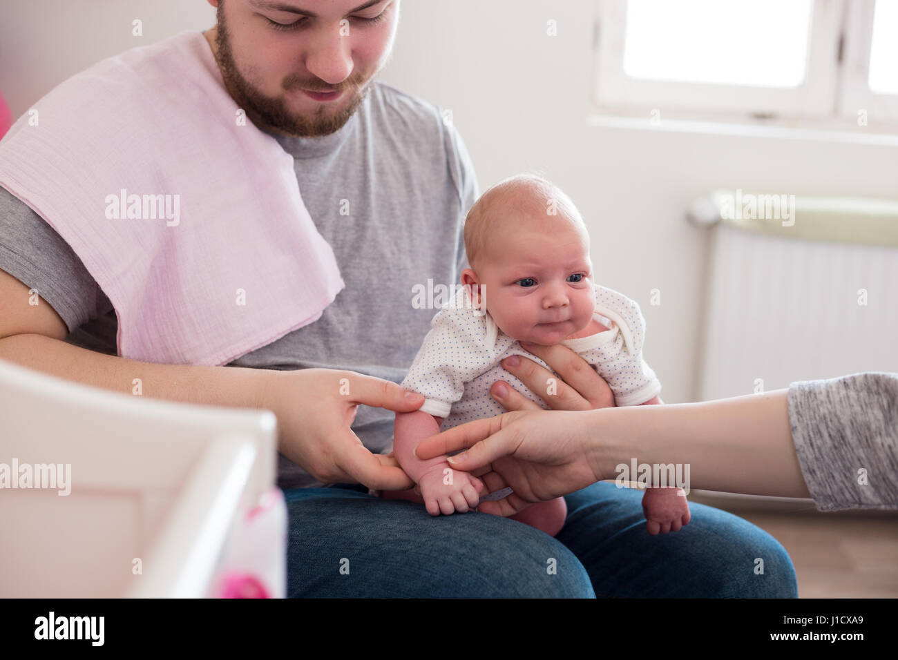 Jeune père de sa fille burping, tenant son affectueusement. Session familiale Lifestyle.. Banque D'Images