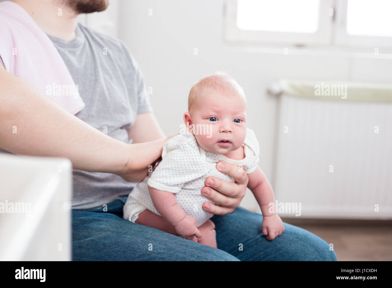 Jeune père de sa fille burping, tenant son affectueusement. Session familiale Lifestyle.. Banque D'Images