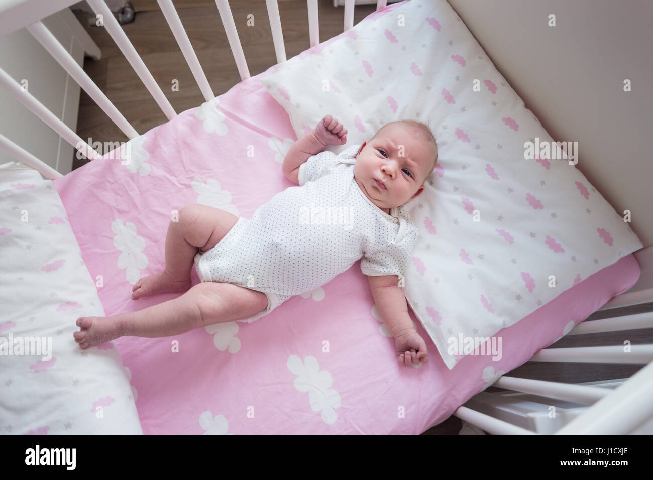 Deux Semaines A Dormir Bebe Fille Dans Son Berceau Sur Les Feuilles Roses Avec Motif Nuage Photo Stock Alamy