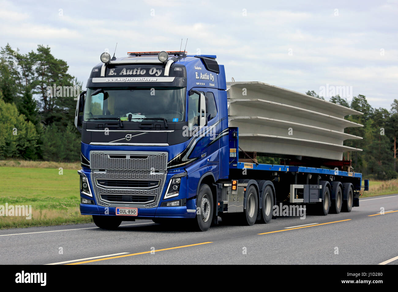 KAARINA, FINLANDE - septembre 9, 2016 : Blue Volvo FH16 semi de E. Autio Oy transporte le béton sur remorque plate le long de la route un jour nuageux. Banque D'Images