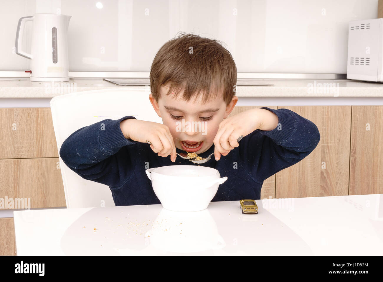 Happy little boy having healthy breakfast Banque D'Images