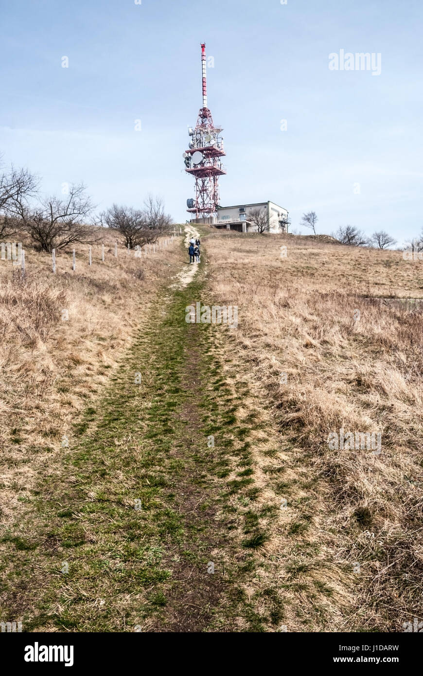 Devin hill avec tour de communication, sentier pédestre et prairie avec quelques arbres dans pavlovske vrchy montagnes en Moravie du sud, au début du printemps journée avec Banque D'Images