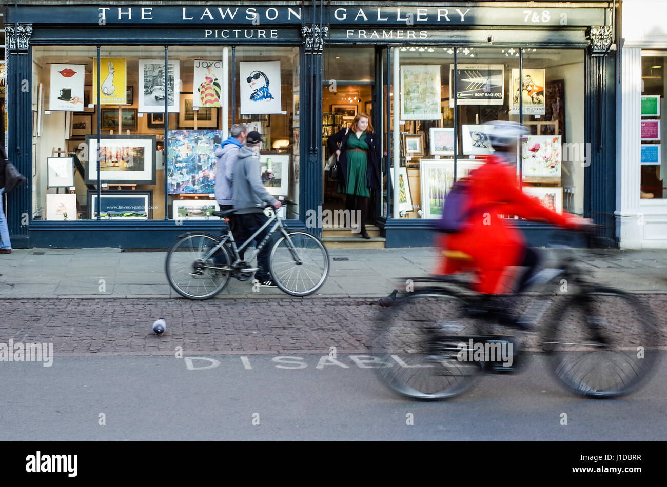 Galerie d'art locale - Les cyclistes passent par le Lawson Art Gallery de Kings Parade, Cambridge, Royaume-Uni Banque D'Images