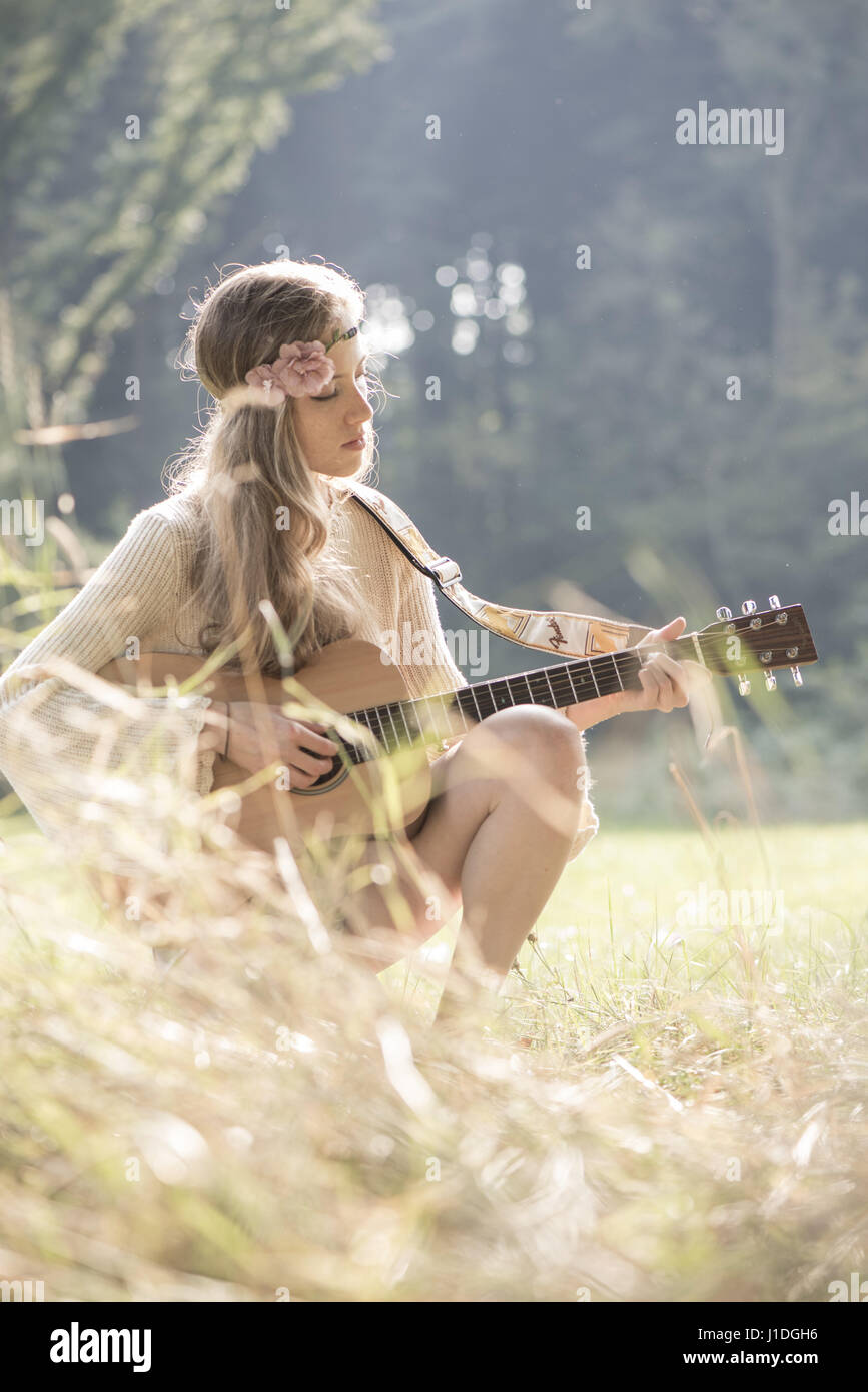 Jeune chanteur compositeur musicien guitare fille en forêt d'automne, Vienne, Autriche (modèle récent) Banque D'Images