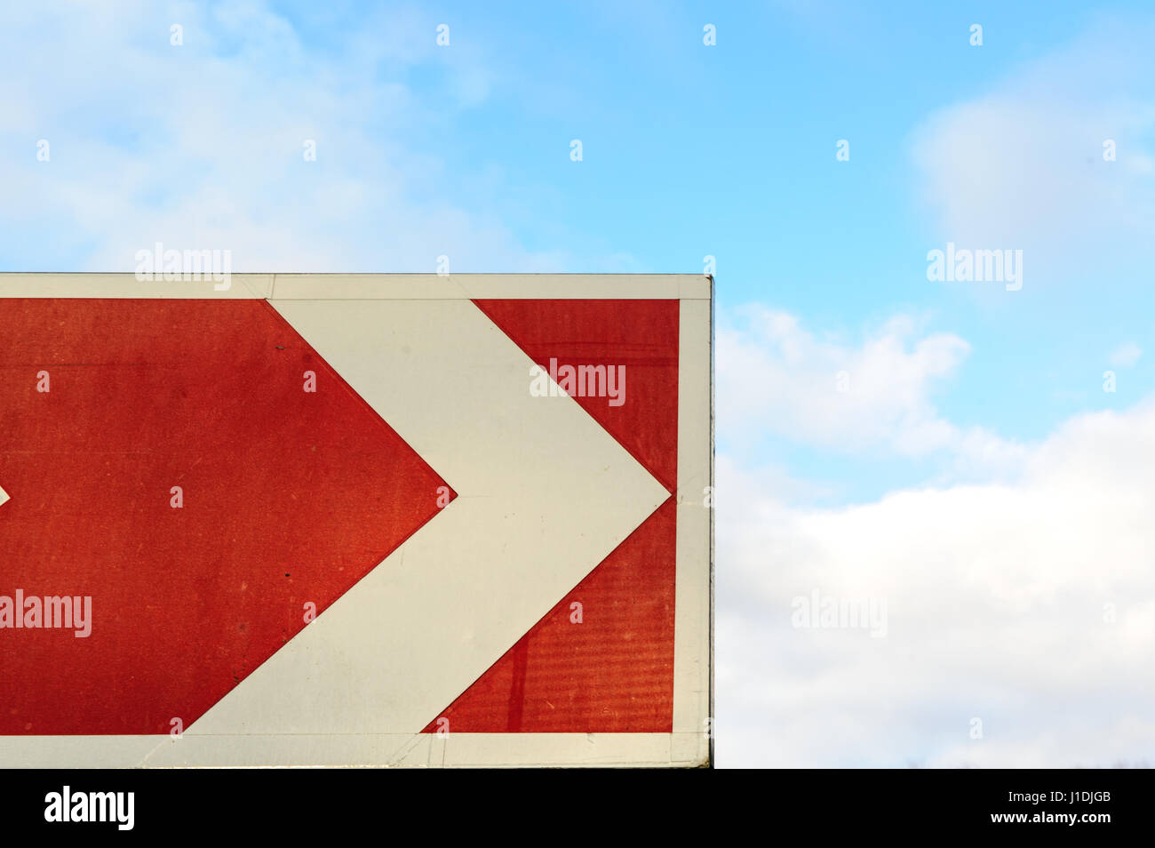 Pointeur flèche rouge sur fond de ciel. Avec bordure et ciel nuageux. Road tournez à signer. Des vacances travel concept. Attention façon Serpentine signe. Tour de l'autoroute. Safe drive image Banque D'Images