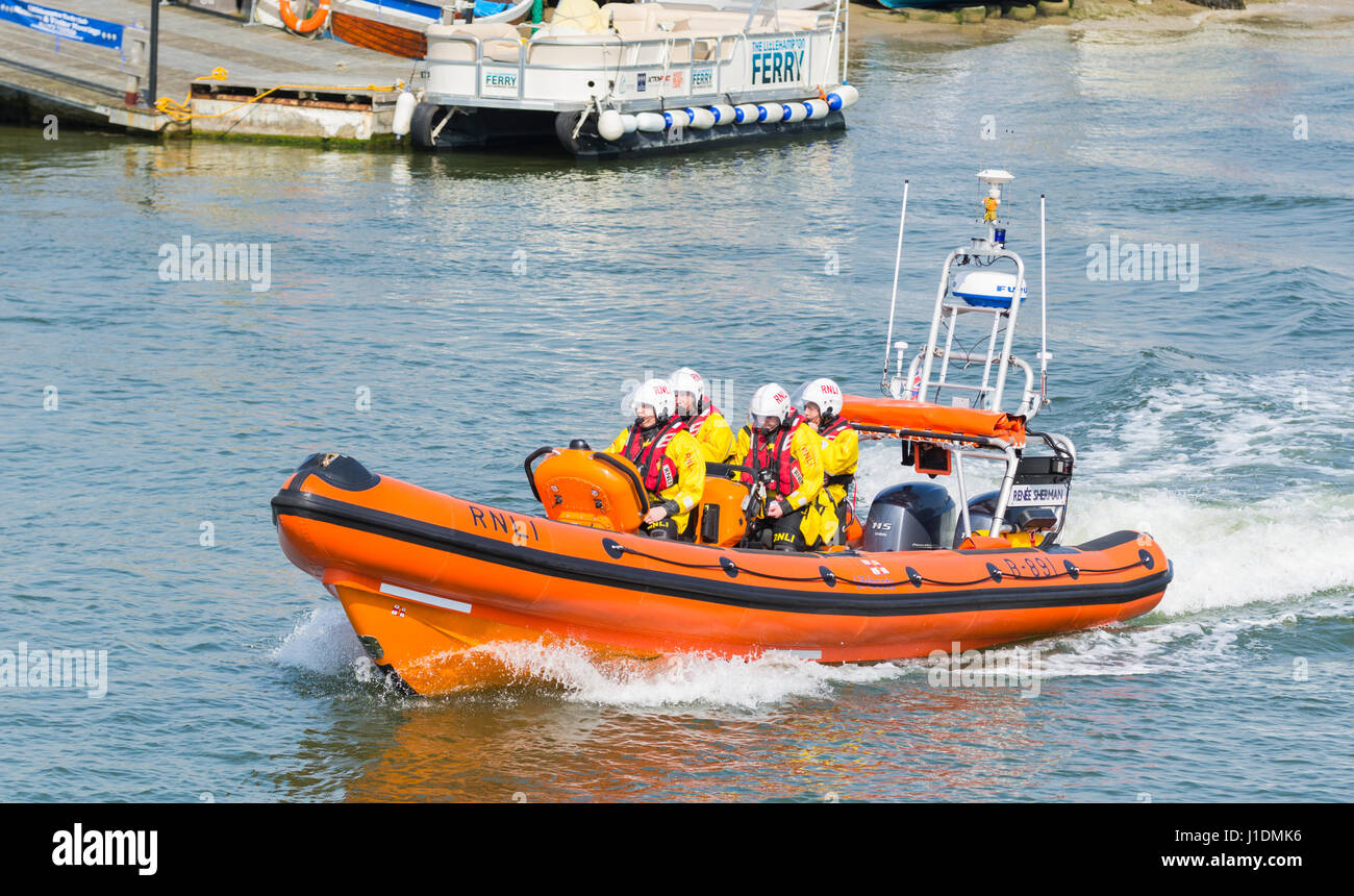 L'équipage RNLI accélère un estuaire fluvial dans une côte côtière de canot de sauvetage sur la rivière Arun, Littlehampton, West Sussex, Angleterre, Royaume-Uni. Banque D'Images
