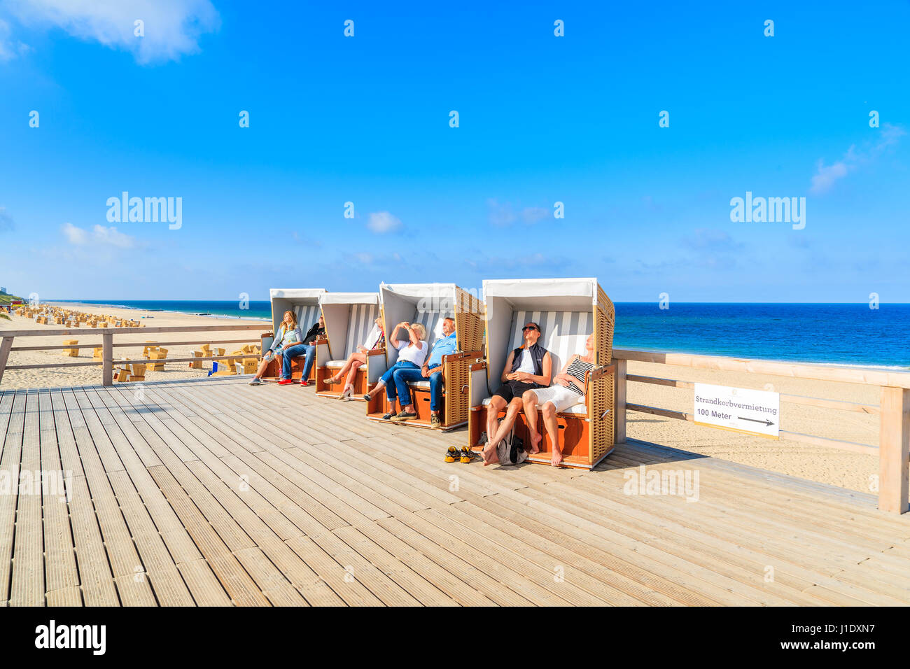 L'île de Sylt, ALLEMAGNE - SEP 6, 2016 : les gens assis dans des chaises en osier sur la promenade côtière en Wenningstedt village. Banque D'Images